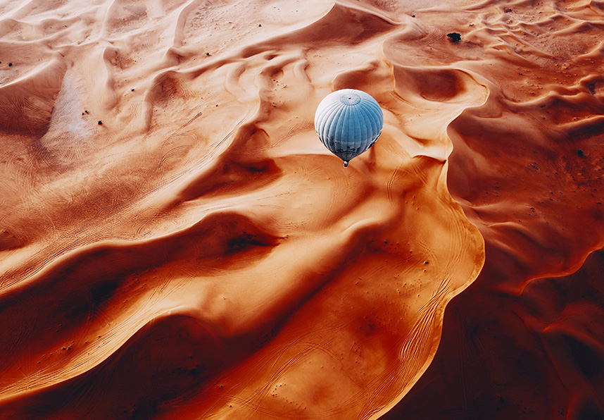 hot air balloon over desert sands