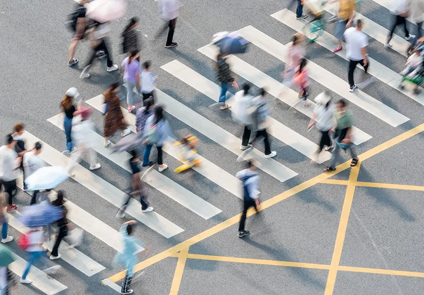 Dozens of people walking on a city crosswalk