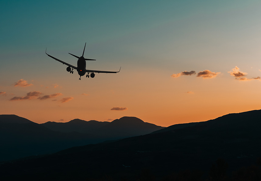 plane flying at sunset