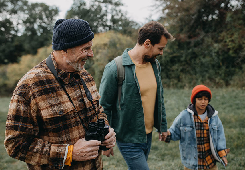 Grandfather, father, and young son birdwatching