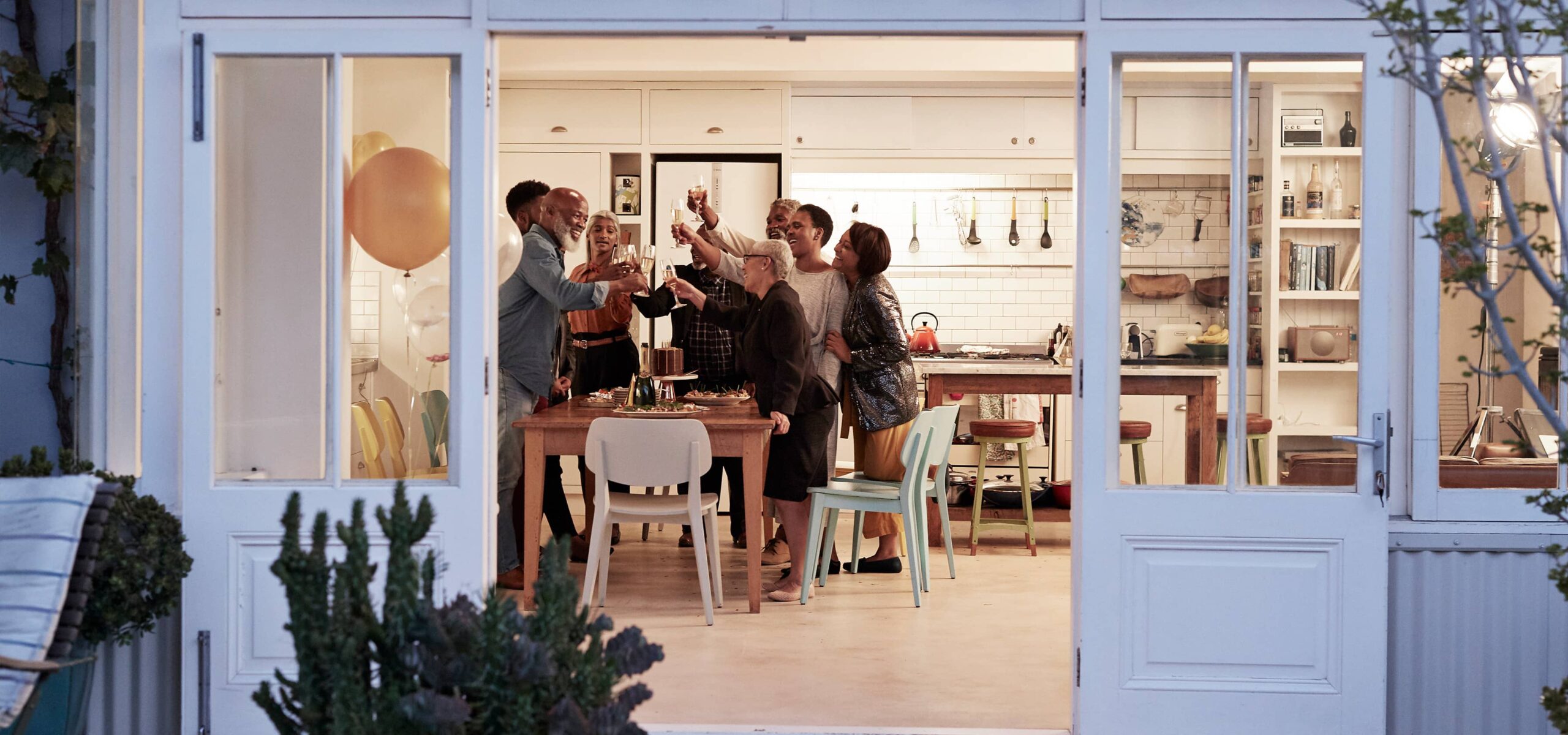 View of friends and family celebrating over dinner in a modern, warm home